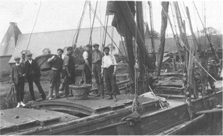 Black and white photo of men standing on a barge.