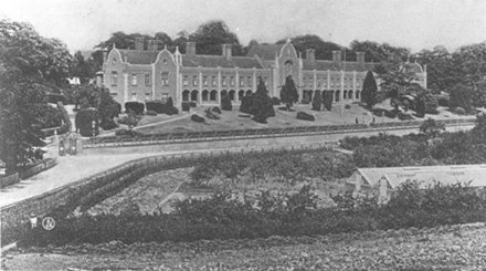 Wide building with trees and gardens