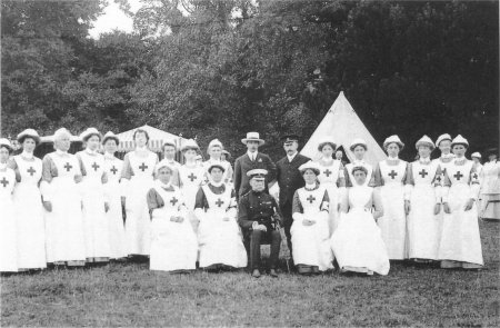 Group of women in white dresses with crosses on front