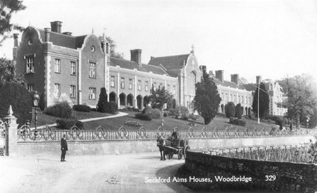 Wide stately house with gardens, road and cart